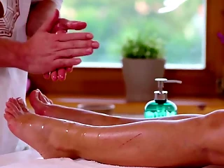 Oiled woman turns the masseur on using feet and enjoys sex